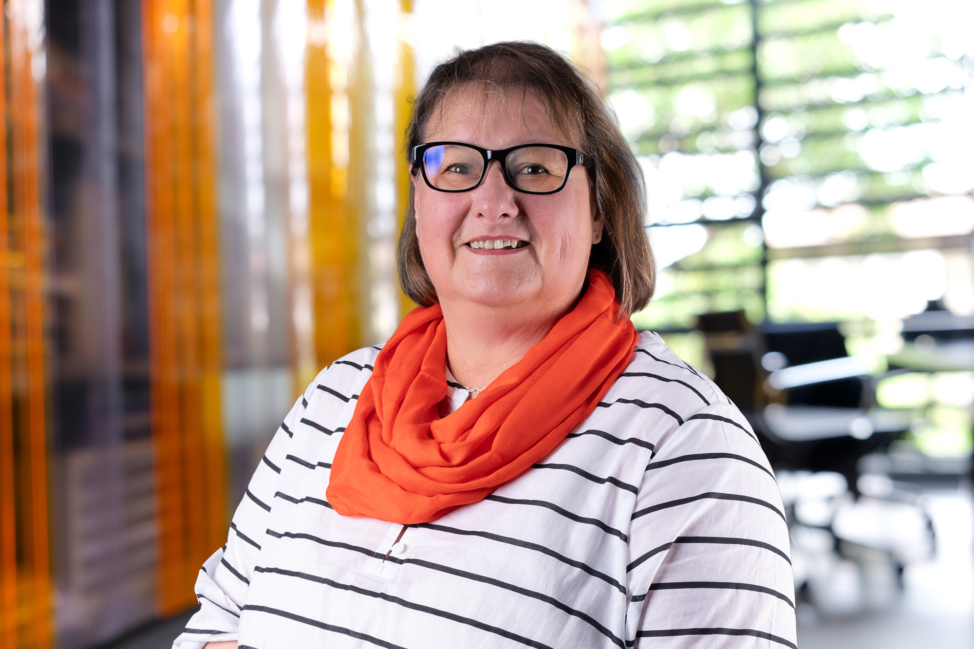 Porträt von Kerstin Zeitler vor warmem Lamellenvorhang