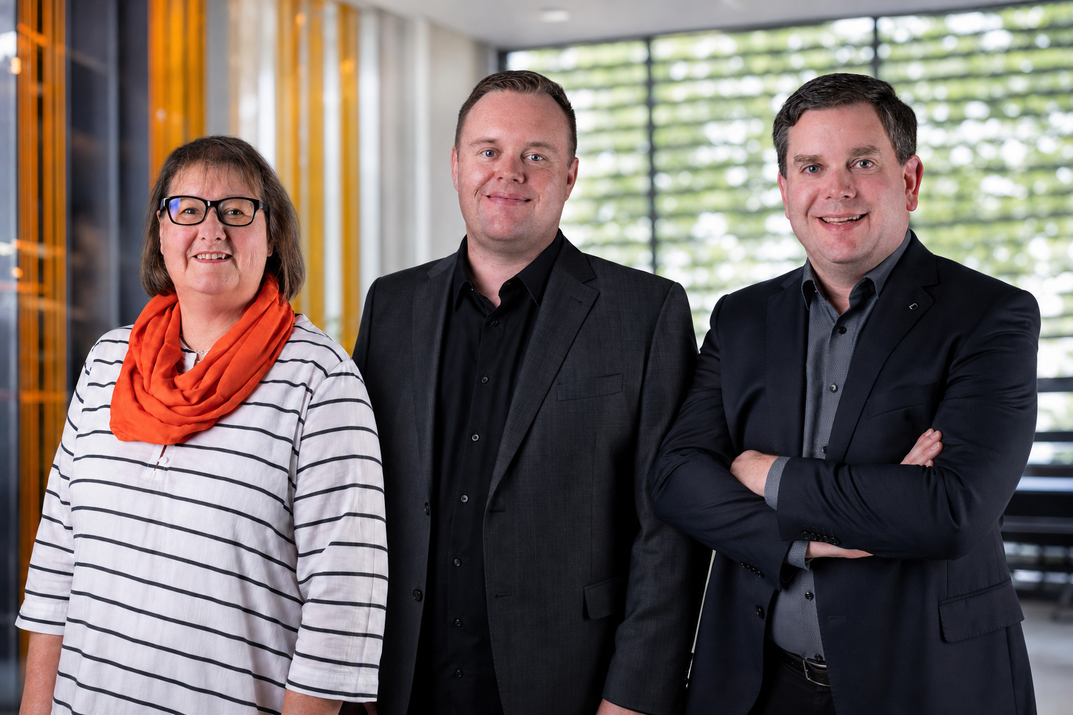 Kerstin Zeitler, Philipp Steuber und Moritz Maenner vor warmem Lamellenvorhang im Büro